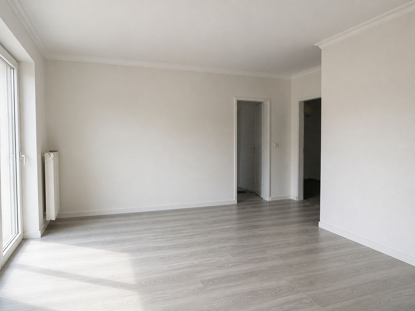 Renovierter Wohnraum in einem Bestandsgebäude mit frisch verputzten Wänden und neu verlegtem Boden